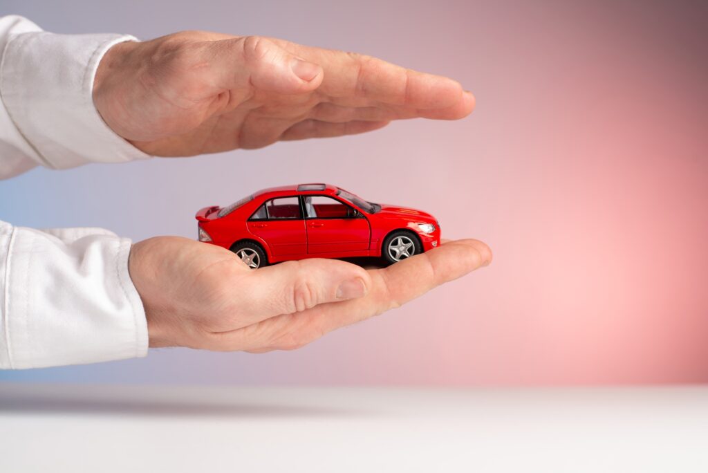 Protection of car concept. Toy car on hand
